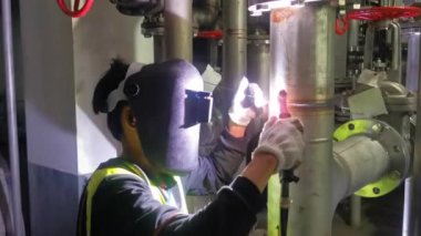 Professional Welder Wears Helmet Working in Heavy Industry Process Pipe, Welding Piping Construction of the Oil, Natural Gas and Fuels Transport Pipeline. Industrial Manufacturing Factory.