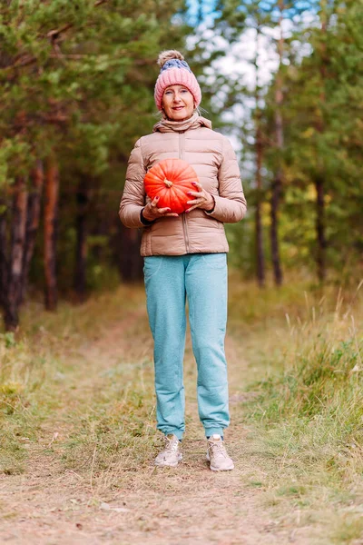 Пожилая Стройная Женщина Держит Оранжевую Тыкву Руках Осенью — стоковое фото
