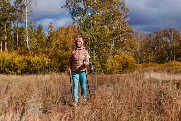 Пожилая Шестидесятилетняя Женщина Спортивной Одежде Занимается Нордической Ходьбой Палками Лесу — стоковое фото