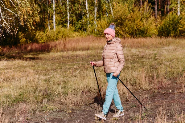 Пожилая Шестидесятилетняя Женщина Спортивной Одежде Занимается Нордической Ходьбой Палками Лесу — стоковое фото