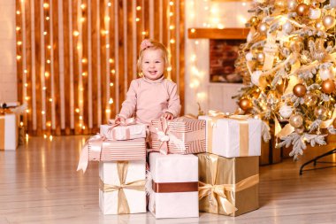 İki yaşında bir kız çocuğu ve içinde Noel hediyesi olan bir sürü kutu.