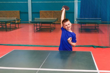 Elinde tenis raketi olan bir çocuk. Zaferin sevinci. masa tenisi