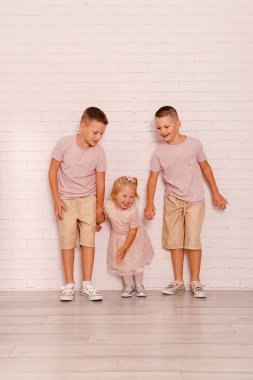 two boys playing with their sister indoors