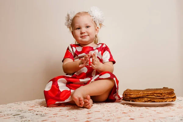 Веселая Маленькая Девочка Сидит Столе Пробует Праздничные Блины Масленица — стоковое фото