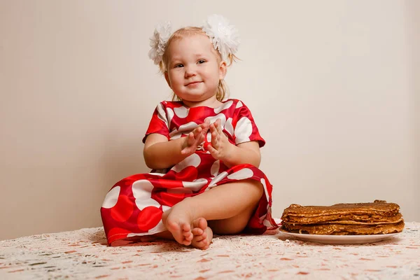 Glada Lilla Flicka Sitter Ett Bord Och Smakar Festliga Pannkakor — Stockfoto