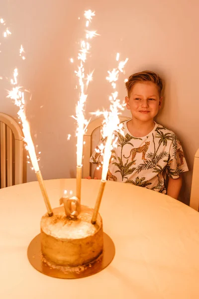 少年と誕生日ケーキ ケーキの上でろうそくや噴水を燃やしたり — ストック写真