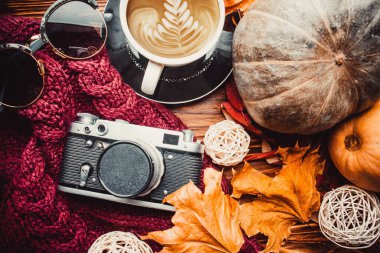Cup of coffee, glasses and a camera on wood white wallpaper with soft sweater