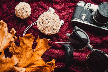 Telefon, gözlük ve ahşap duvar kağıdında yumuşak kazaklı bir kamera.