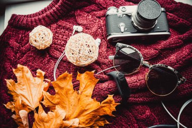 Gözlükler ve ahşap duvar kağıdında yumuşak süveterli bir kamera.