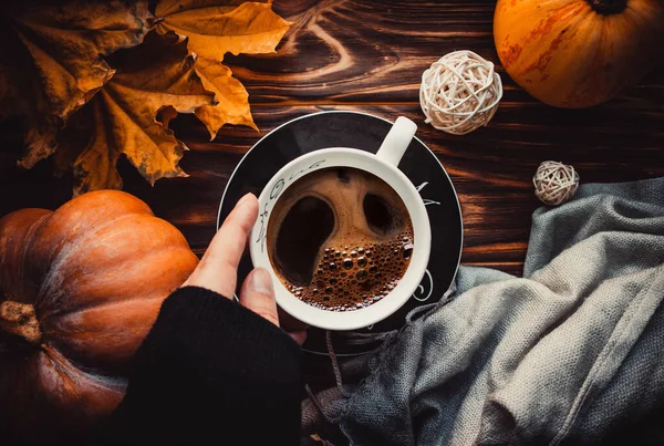Cup of coffee on wood brown background with scarf