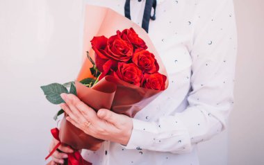Beautiful bouquet of red roses on a white background with green leaves