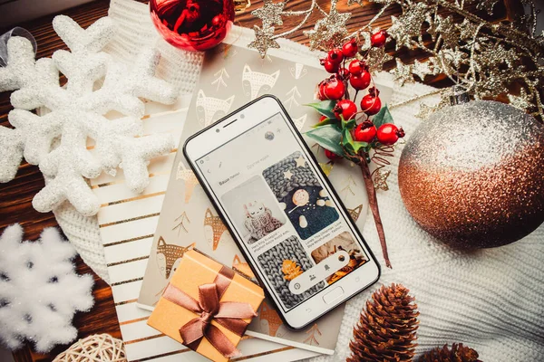 Phone and christmas decorations on a wood brown background with warm sweater