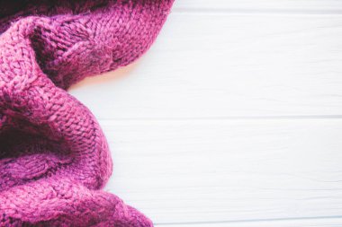 Sonbaharda beyaz ahşap arka planda koyu renk süveterin yumuşak dokusu