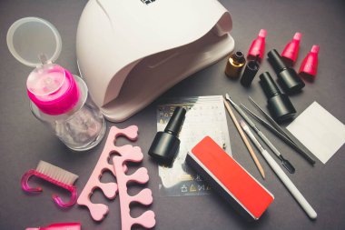 Jel cilası ve aksesuarlı siyah kağıt zemin üzerinde morötesi lamba ve dekor.