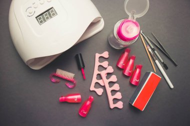 Koyu arkaplanda tırnak törpüsü ve aksesuarlı çivi lambası.