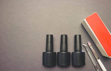 Manikür için fırçalı siyah kağıt arkaplan üzerindeki jel cilası ve tırnak törpüsü