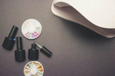 Koyu arkaplanda morötesi lamba ve dekor. Jel cilası ve manikür için koyu kağıt arka plan.