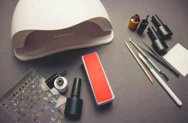 Karanlık arka planda morötesi lamba ve dekor jel cilası ve aksesuarlarla.