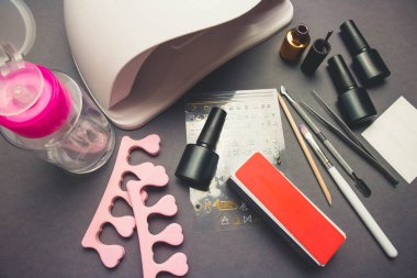 Jel cilası ve aksesuarlı siyah kağıt zemin üzerinde morötesi lamba ve dekor.