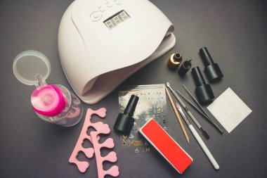 Jöle cilası ve fırçayla arka planda morötesi lamba ve dekor.