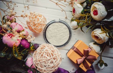 Makyaj için fosforlu kalem ve ahşap arkaplanda çiçekler.