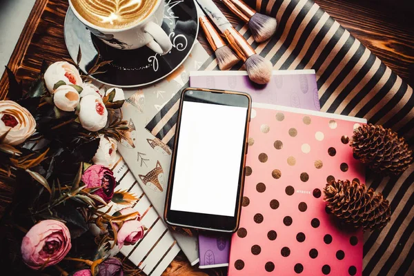 Telefon, kupa ve çiçekler ahşap bir arka planda kağıt ile. Boşluğu kopyala