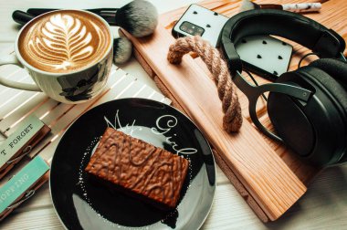 Bir fincan kahve ve ahşap beyaz arka planda fırçalı tatlı kek. Flatlay. Bahar fotoğrafçılığı