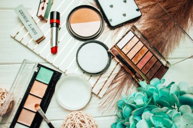 Telefon ve kozmetik ürünleriyle ahşap beyaz arka planda göz farı ve ruj. Flatlay. Bahar fotoğrafçılığı. Boşluğu kopyala