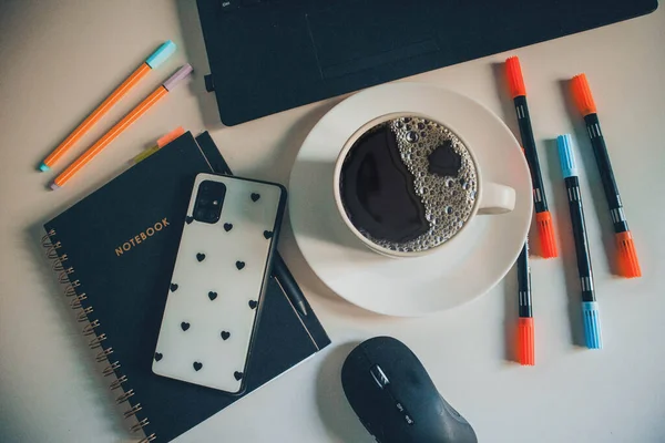 Cup of coffee on wooden tray with phone, glasses, notebook and headphones. Autumn flatlay.