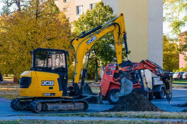 Kemerli kazıcı JCB 65 ve makasla yükleyici Locust 903 yolda çalışıyor