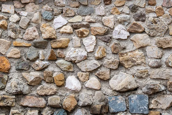 Çeşitli renklerden oluşan büyük yuvarlak taş bir duvar. Doku veya arkaplan