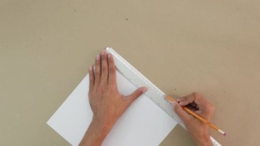 El işi kağıdındaki beyaz bir kağıt parçasında izler var. El yapımı proje. Kahverengi eller. İspanyol tenli..