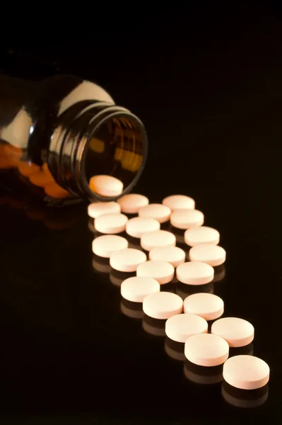 Medicine bottle with spilled pills. — Stock Photo, Image