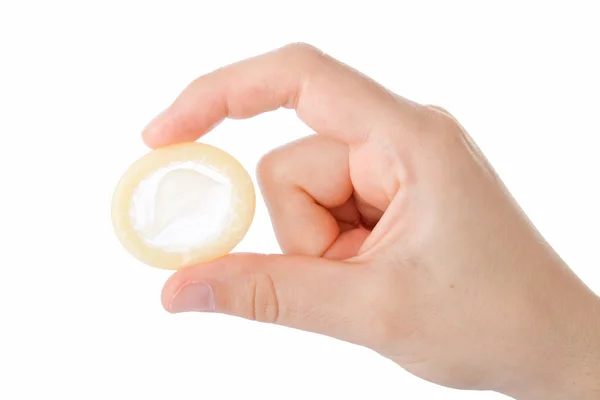 Beyaz arka planda izole edilmiş bir prezervatif tutuyor. — Stok fotoğraf