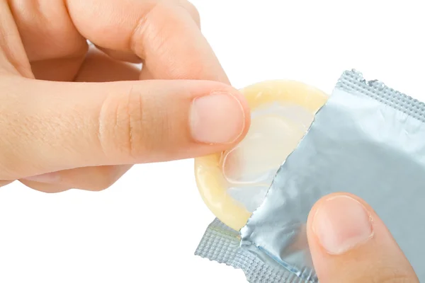 Mãos desembrulhando um preservativo isolado no fundo branco — Fotografia de Stock