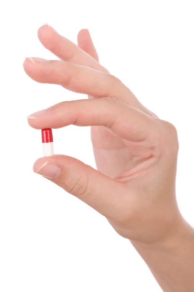 Mão segurando uma cápsula ou comprimido isolado em branco — Fotografia de Stock
