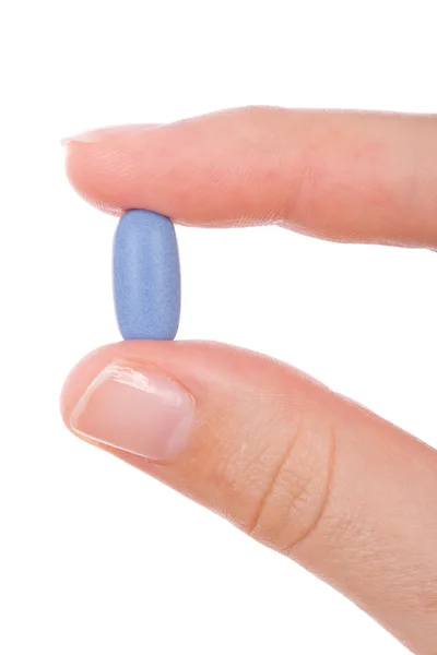 Рука держит синюю таблетку, изолированную на белом — стоковое фото