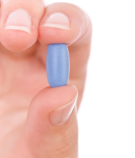 Mão segurando uma pílula azul de perto — Fotografia de Stock