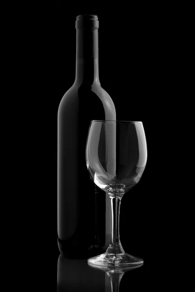 Elegante botella de vino y copa de vino en un fondo negro —  Fotos de Stock