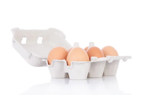 Meia dúzia de ovos de galinha marrom em caixa isolada em fundo branco — Fotografia de Stock