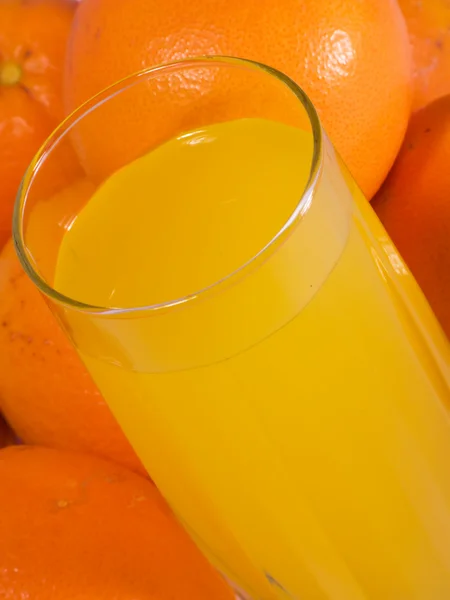 Стакан натурального апельсинового сока с апельсинами — стоковое фото