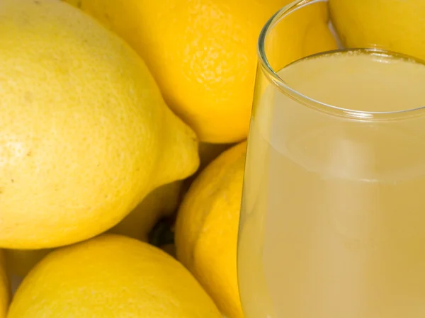 Стакан натурального лимонада с несколькими лимонами — стоковое фото