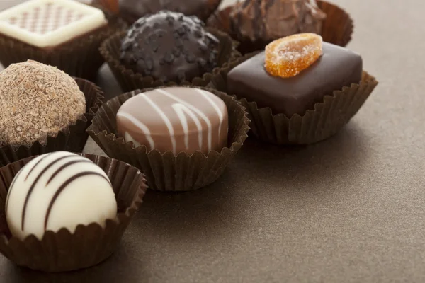 Diverse gourmet choklad konfekt i pappersmuggar — Stockfoto