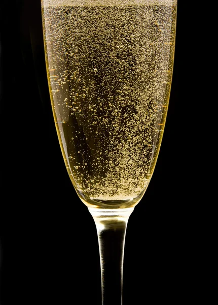 Flöte mit perlendem Champagner vor schwarzem Hintergrund — Stockfoto