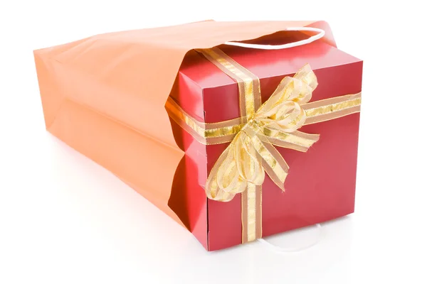 Κόκκινο δώρο με το χρυσό δοξάρι μέσα απομονώνονται σε λευκό φόντο μια τσάντα για ψώνια — 图库照片