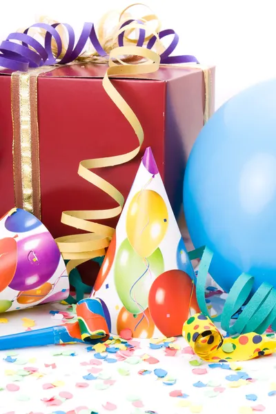 Cadeau, chapeaux de fête, cornes ou sifflets, confettis et ballons sur fond blanc . — Photo
