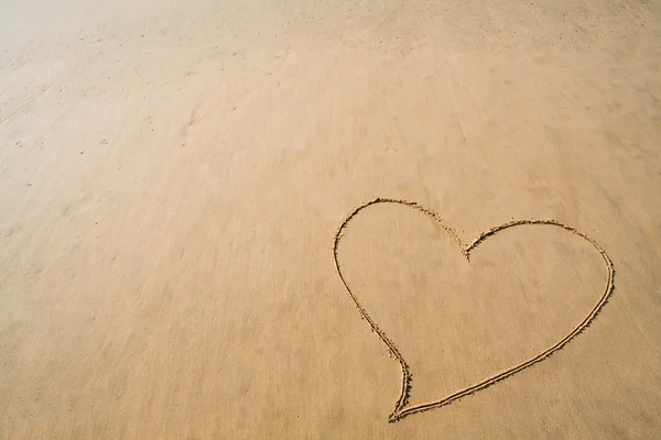 Сердце, нарисованное в гладком пляжном песке — стоковое фото