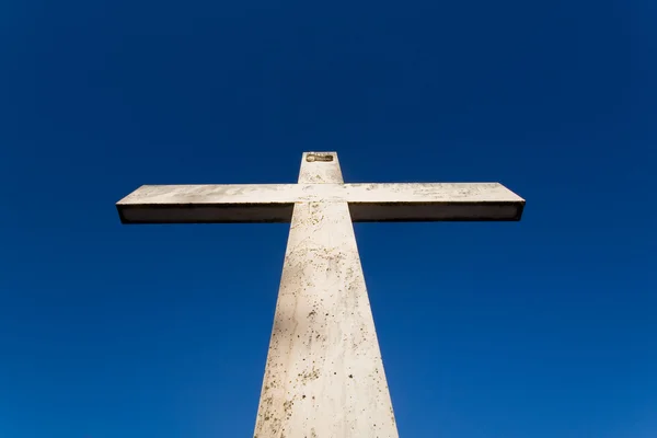 Grande cruz de pedra contra céu azul claro — Fotografia de Stock