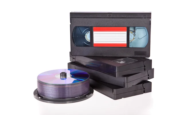 Vieilles cassettes vidéo avec disques DVD isolés sur fond blanc — Photo