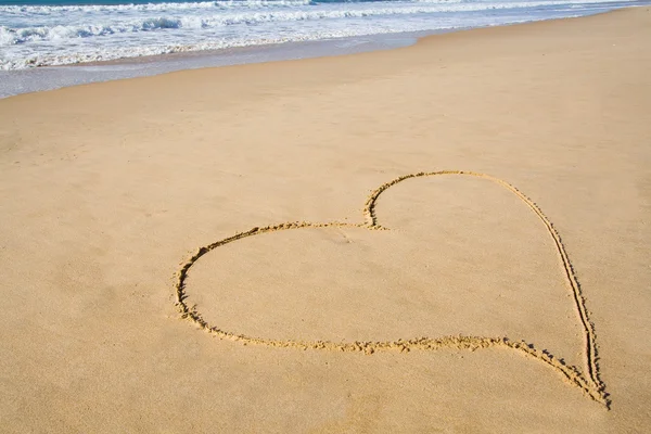 Hjärtat i den mjuk sandstranden Stockbild